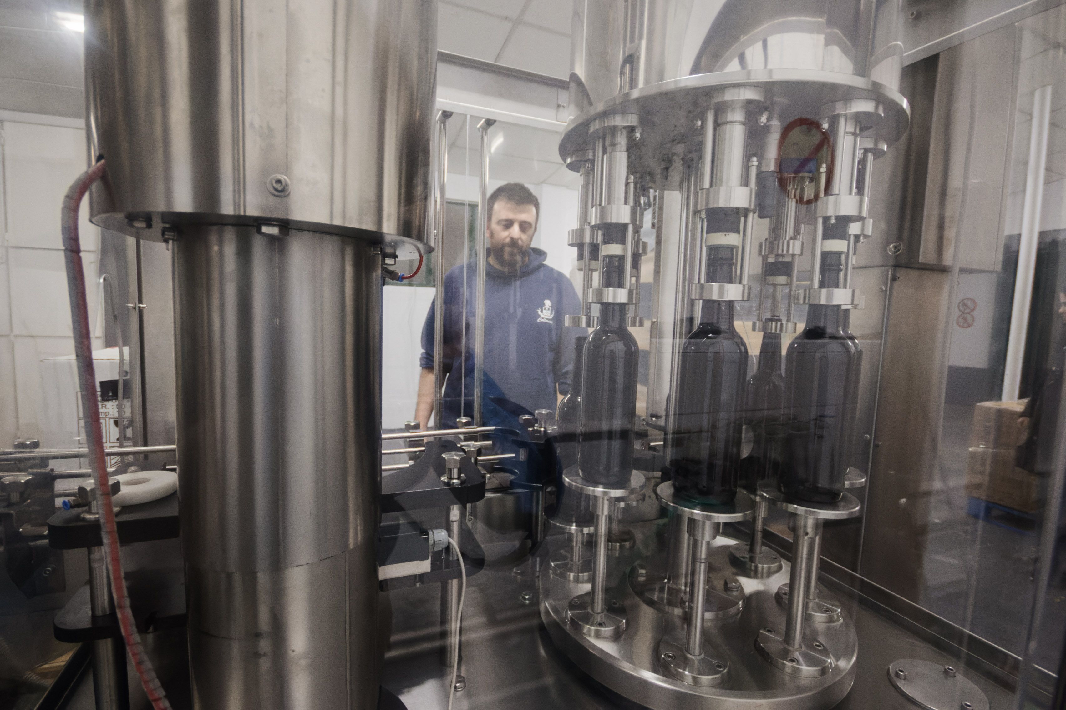 Oliver configura la embotelladora en la bodega ubicada en Chiclana.
