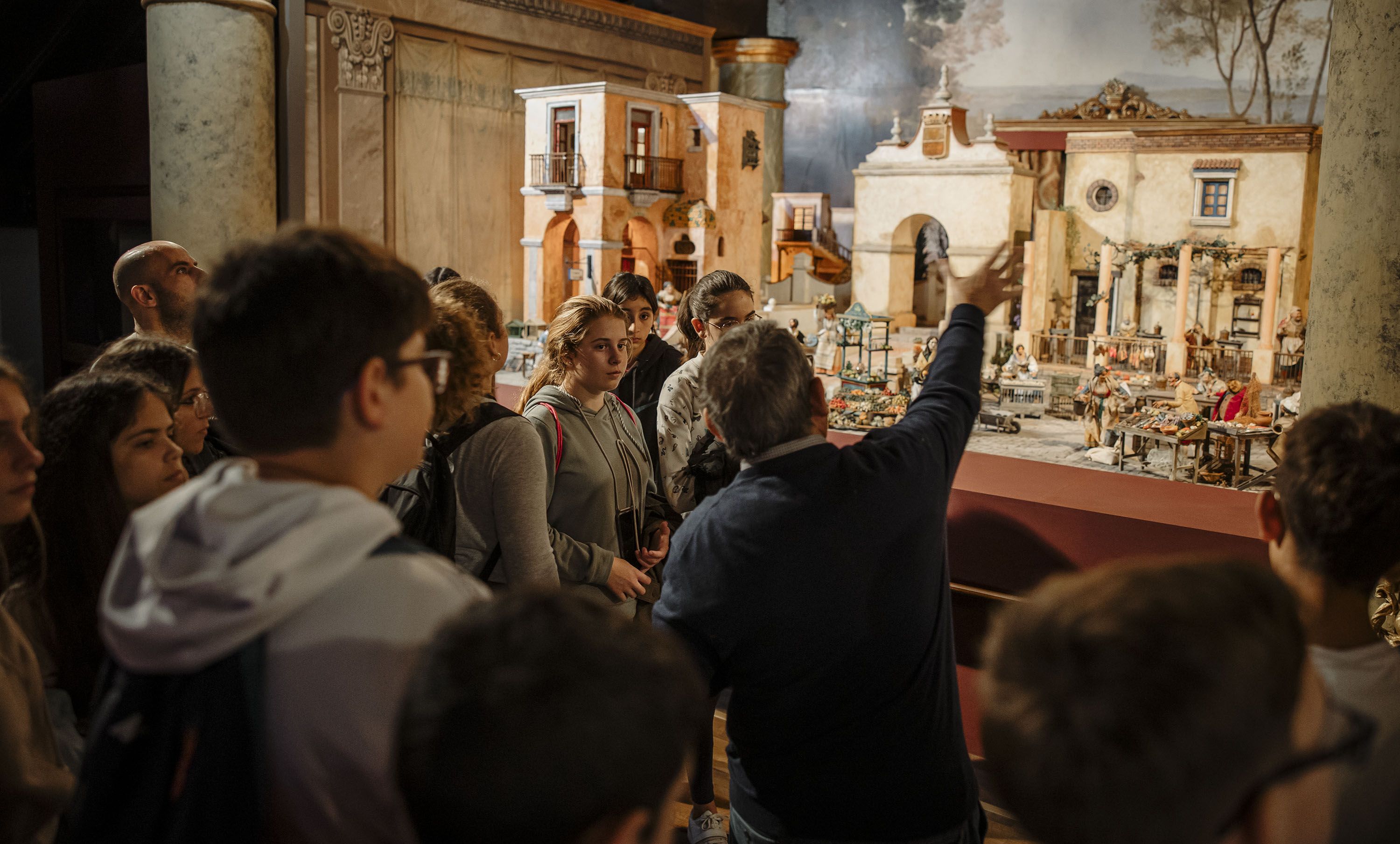 Juan Camas haciendo de guía en una visita al Museo del Belén en Jerez a un numerosos grupo de estudiantes.