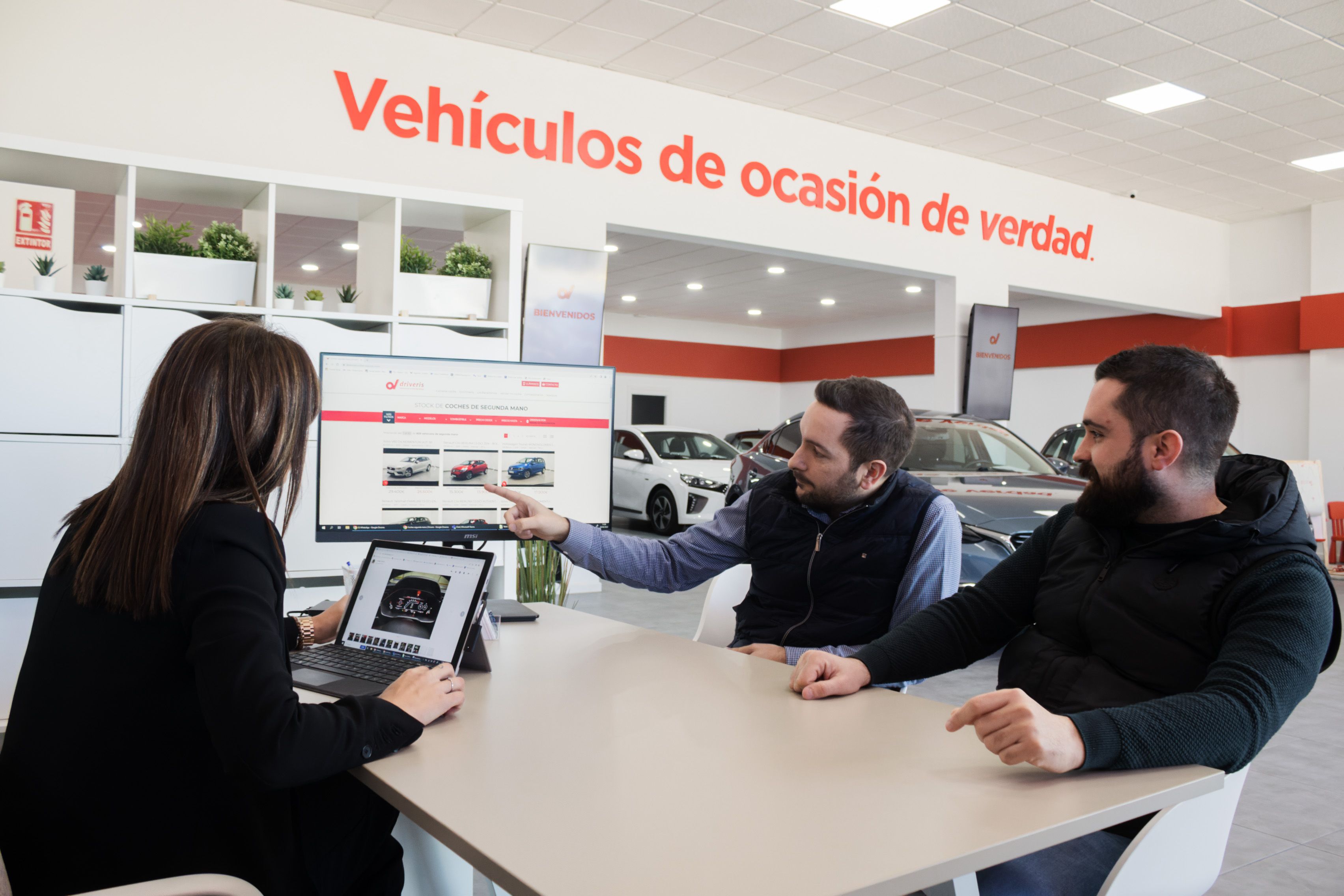 Una asesora orientando a unos clientes en la compra de un vehículo.    CANDELA NUÑEZ