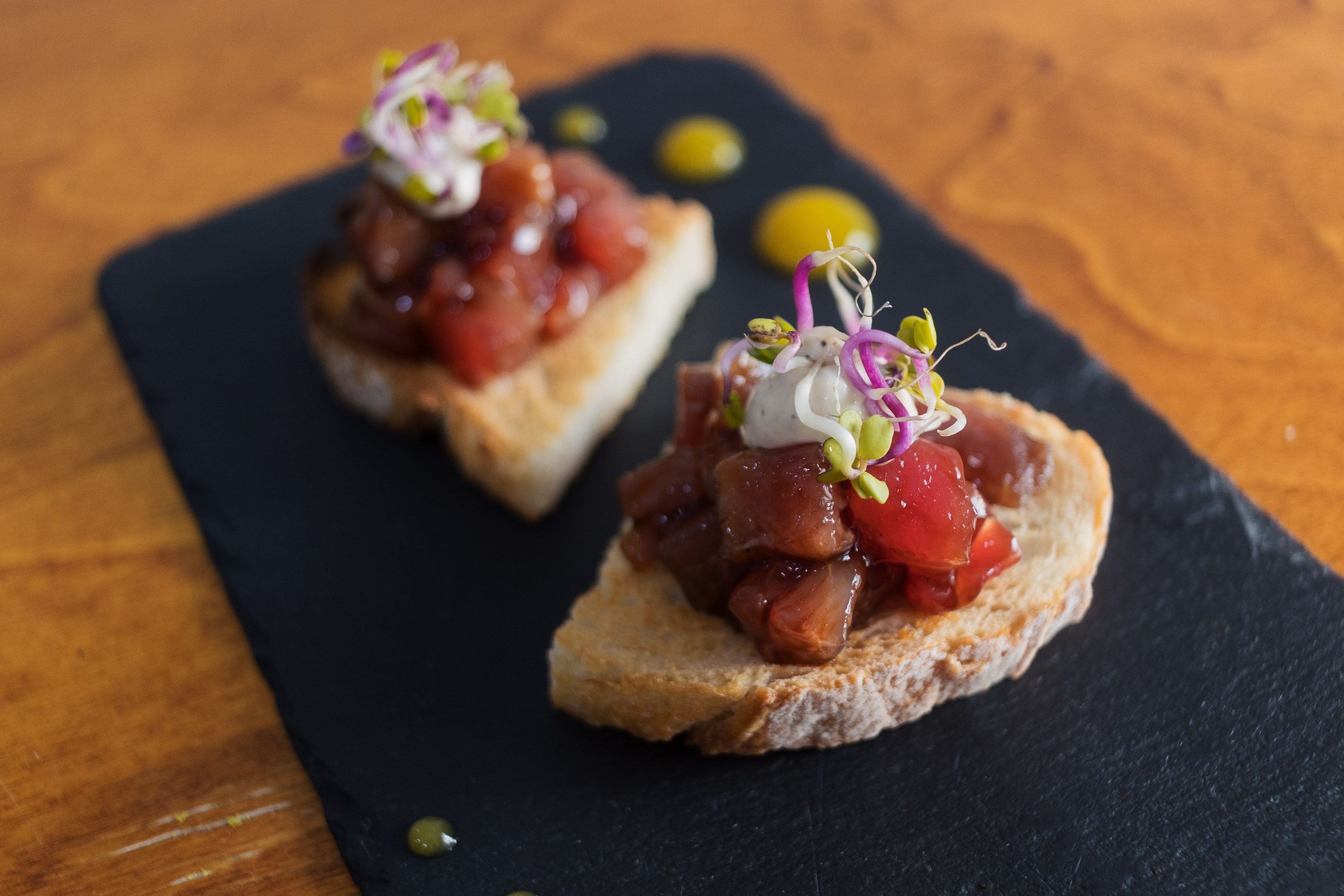 Tosta de atún macerado con emulsión de trufa y germinado de rabanillos. 