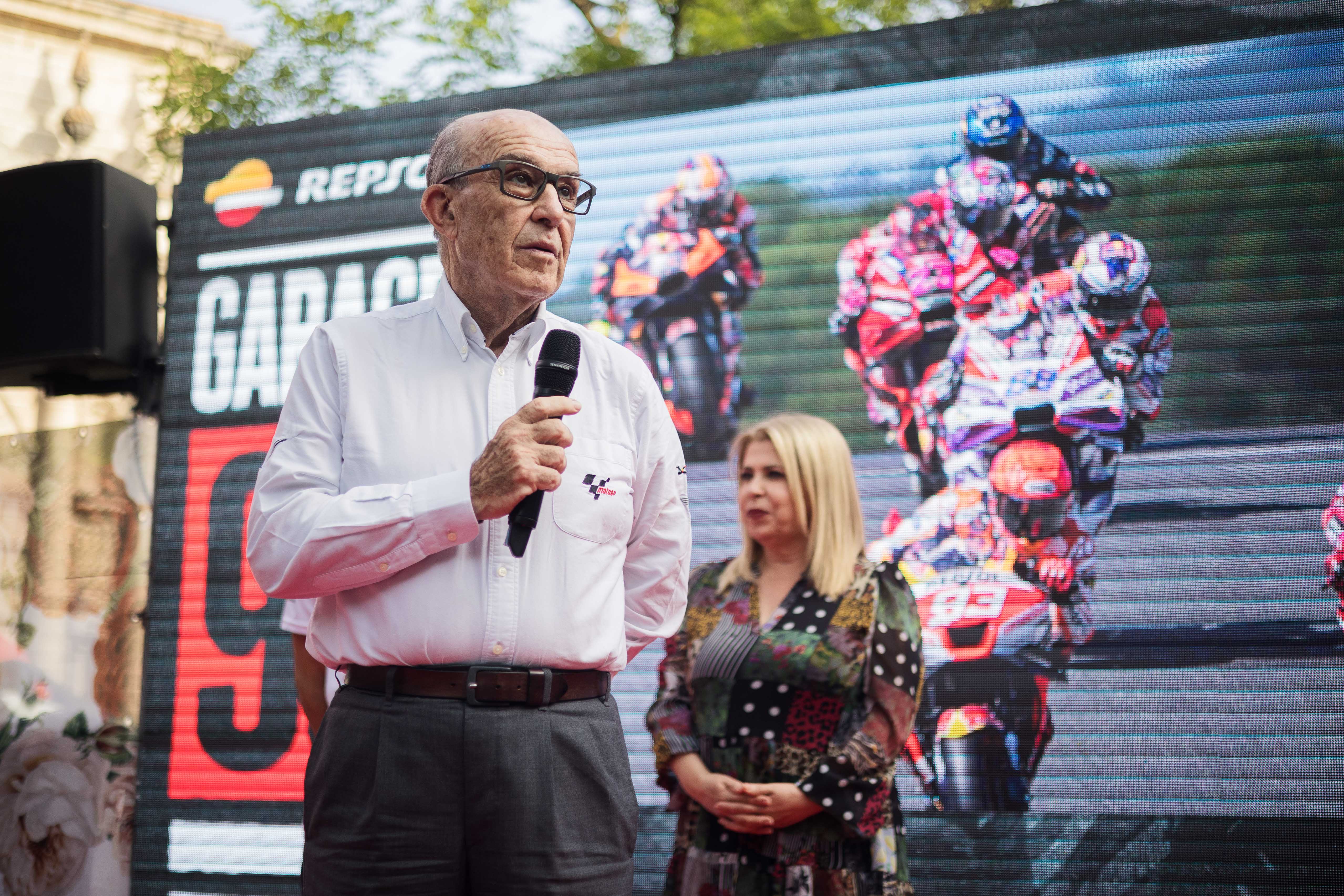 Carmelo Ezpeleta dirigiéndose al público ante la gran pantalla con imágenes del seis veces campeón del mundo Marc Márquez.       MANU GARCÍA