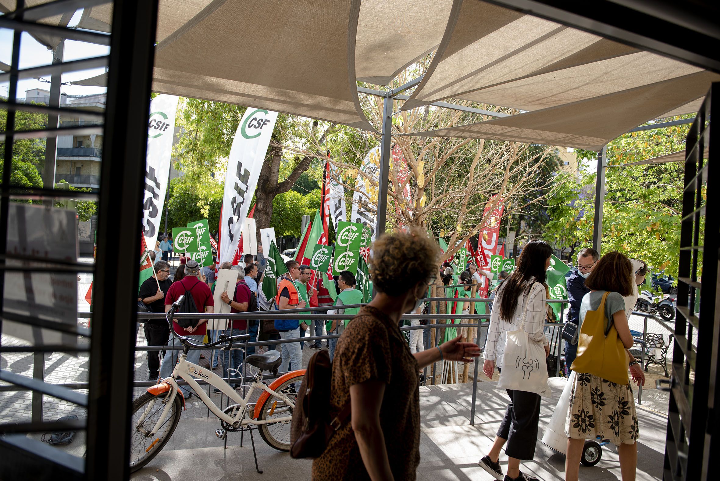 Pacientes salen de un centro de salud en Triana mientras los sindicatos se manifiestan.