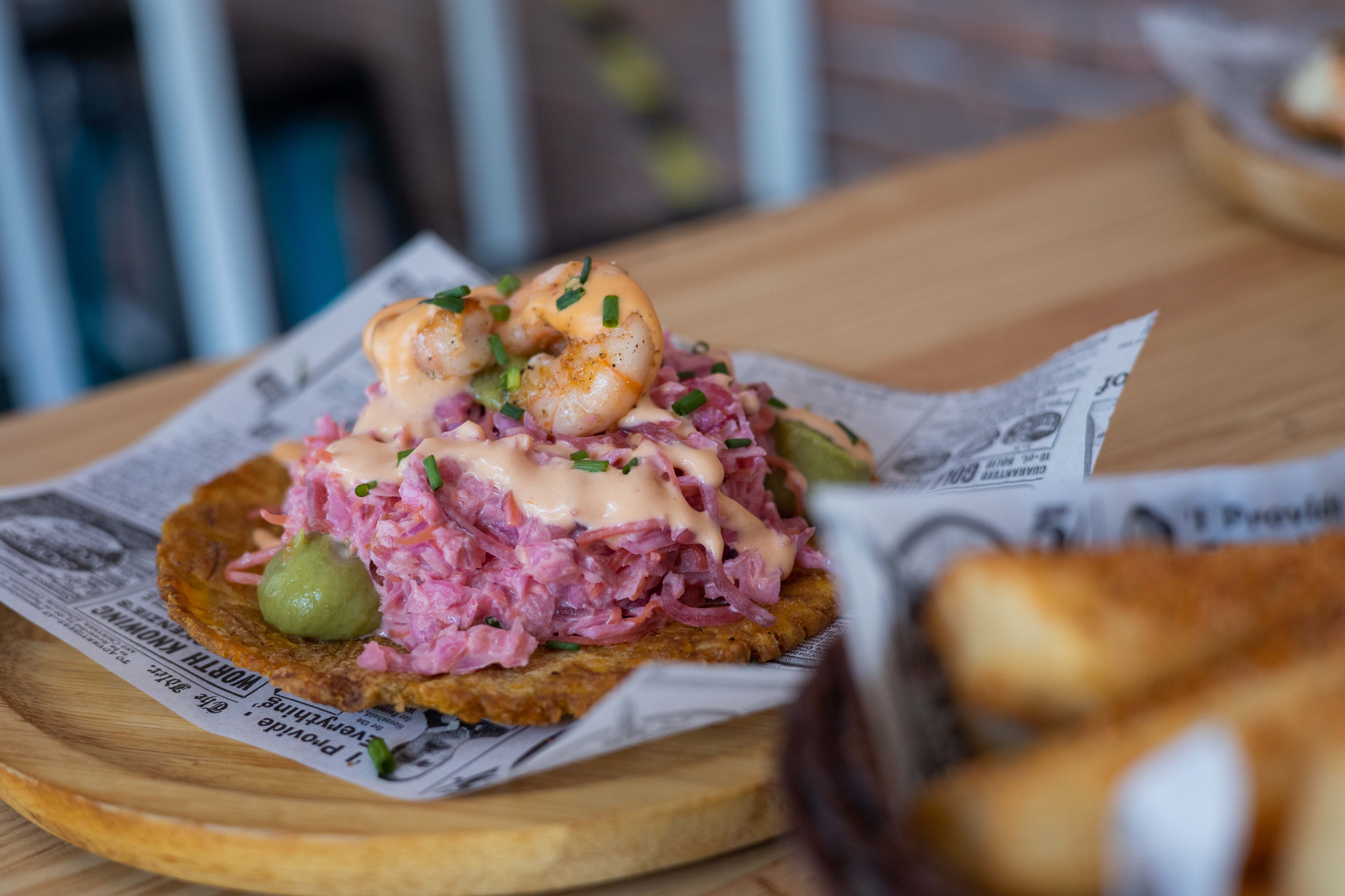 Patacón caribeño con ensalada, langostinos, piña y guacamole. 