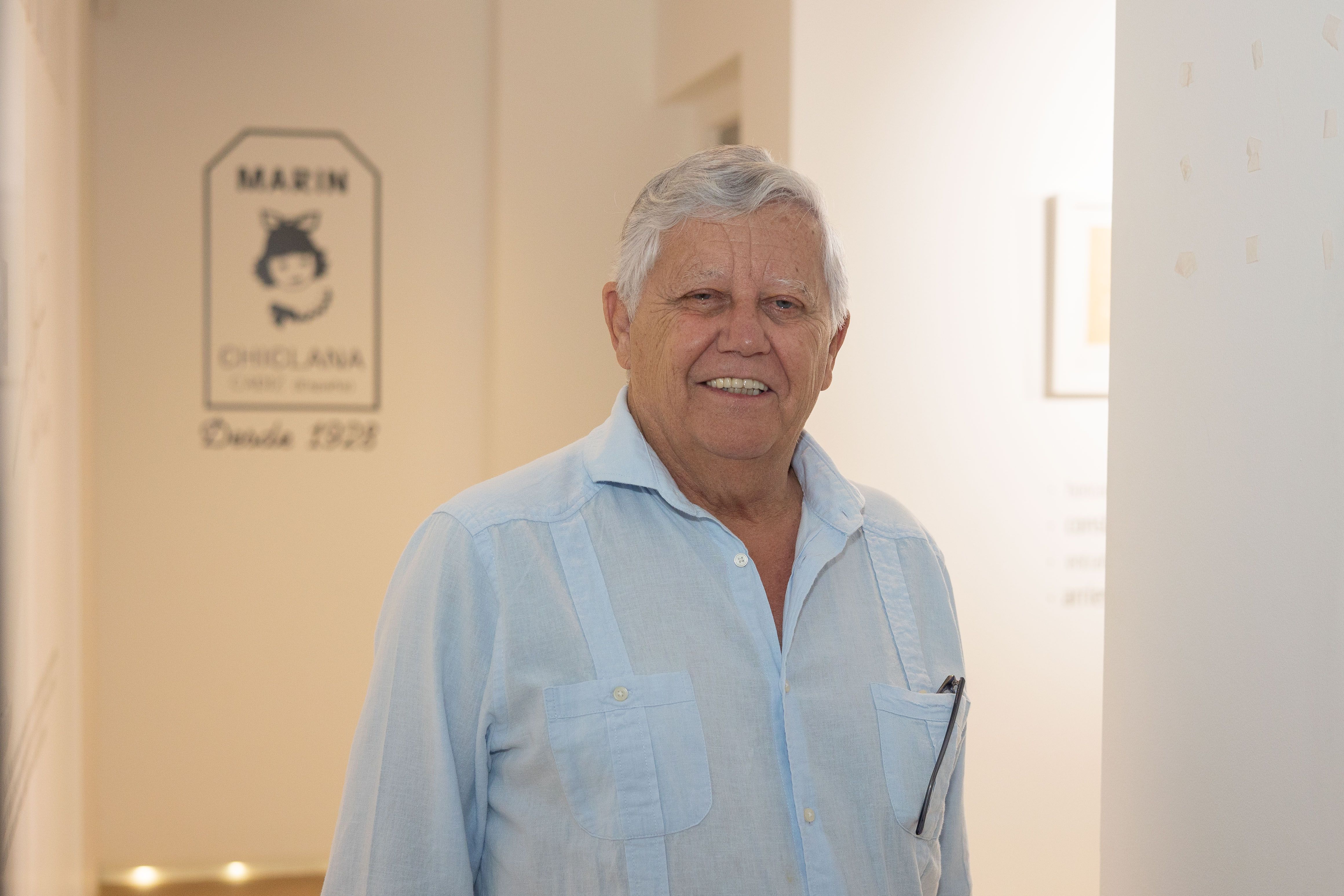Ernesto posa junto al logo de la empresa familiar. 