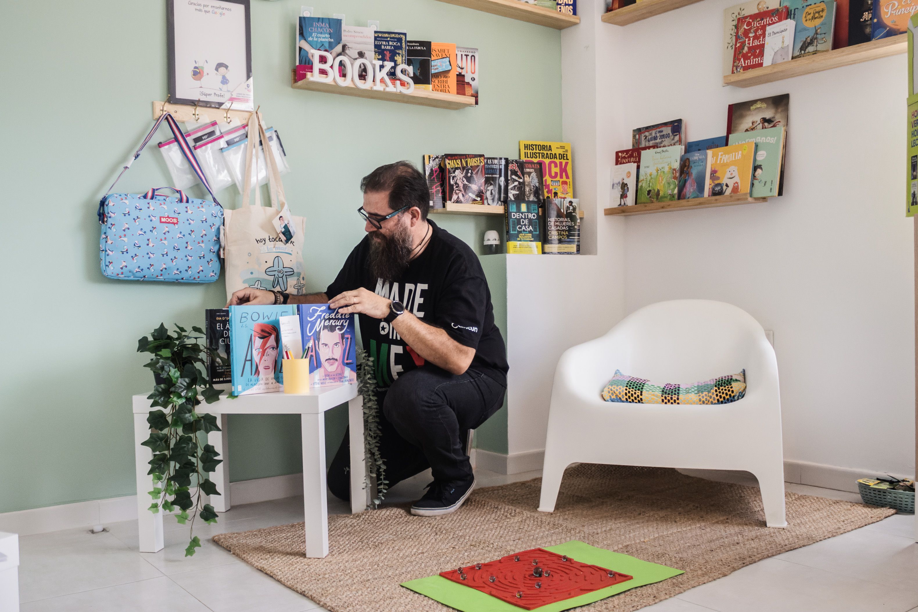 El emprendedor coloca unos libros en el local. 