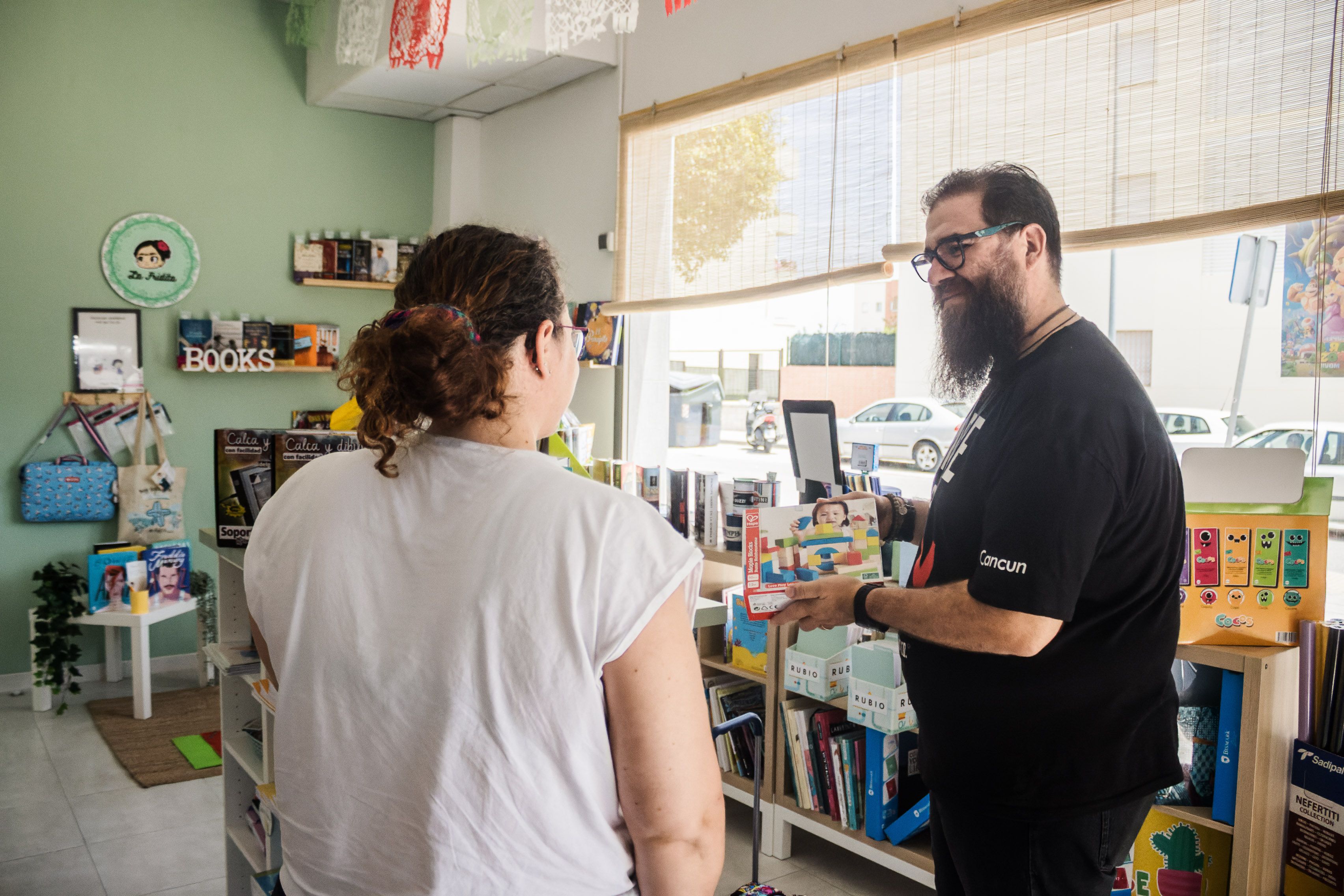 José Antonio atiende a una clienta en la papelería. 