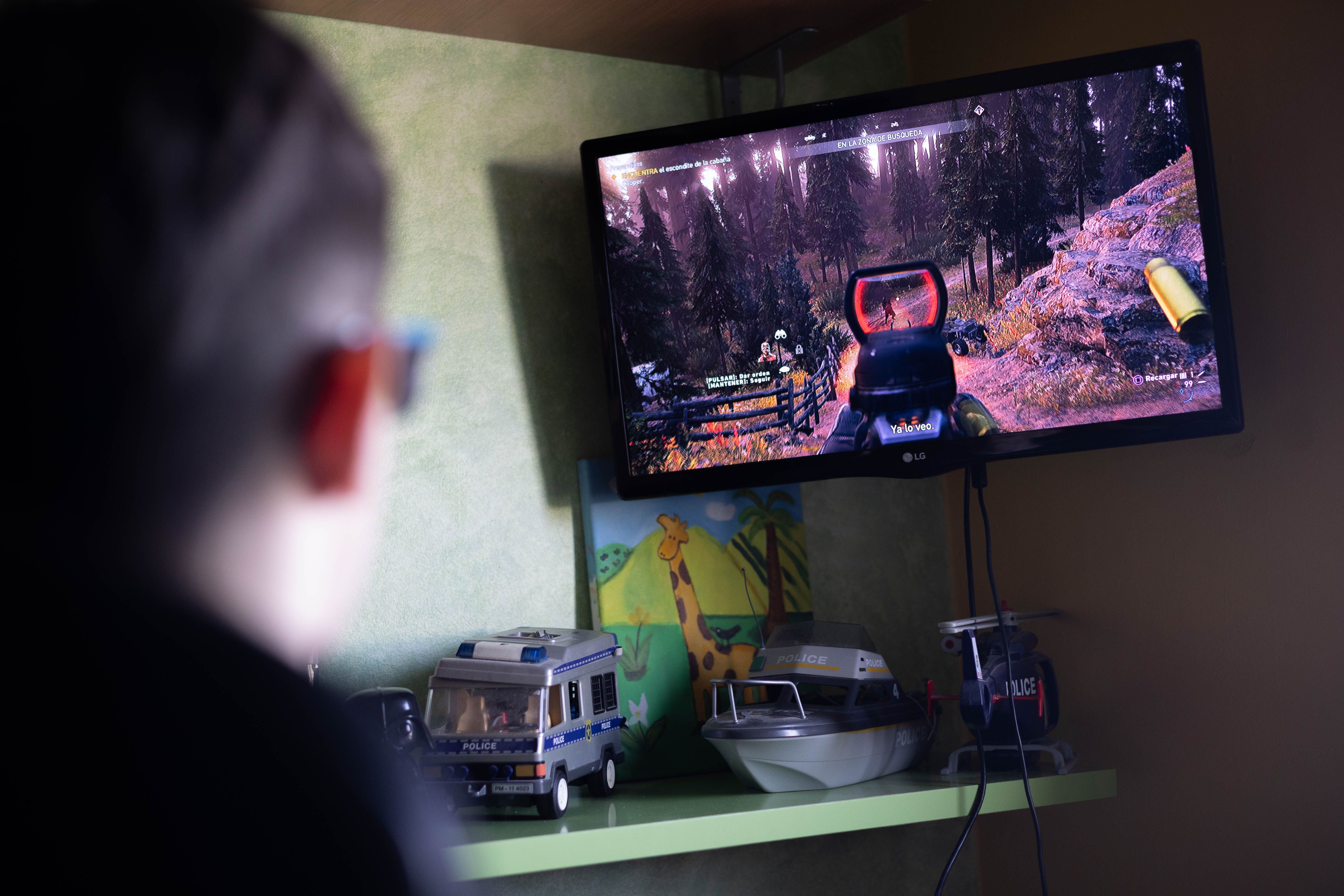 Ángel jugando a un videojuego en su cuarto. 