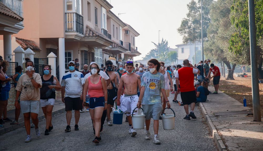 Los vecinos movilizados con cubos para apagar el incendio en Las Canteras.