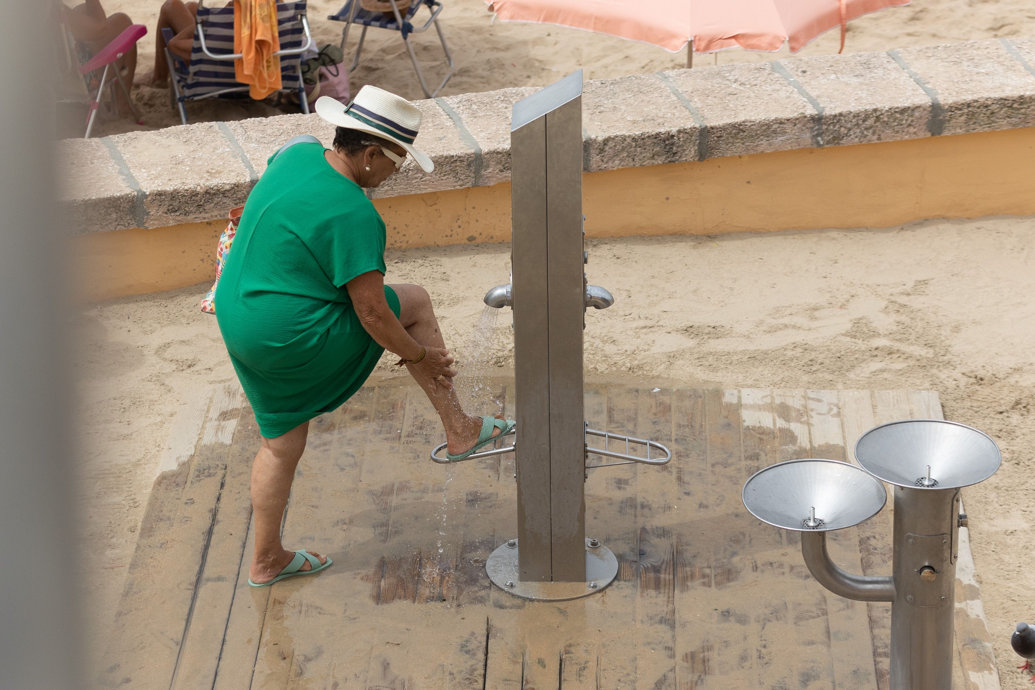 Una usuaria, en una imagen de archivo, utiliza un lavapiés en la playa de La Caleta. 