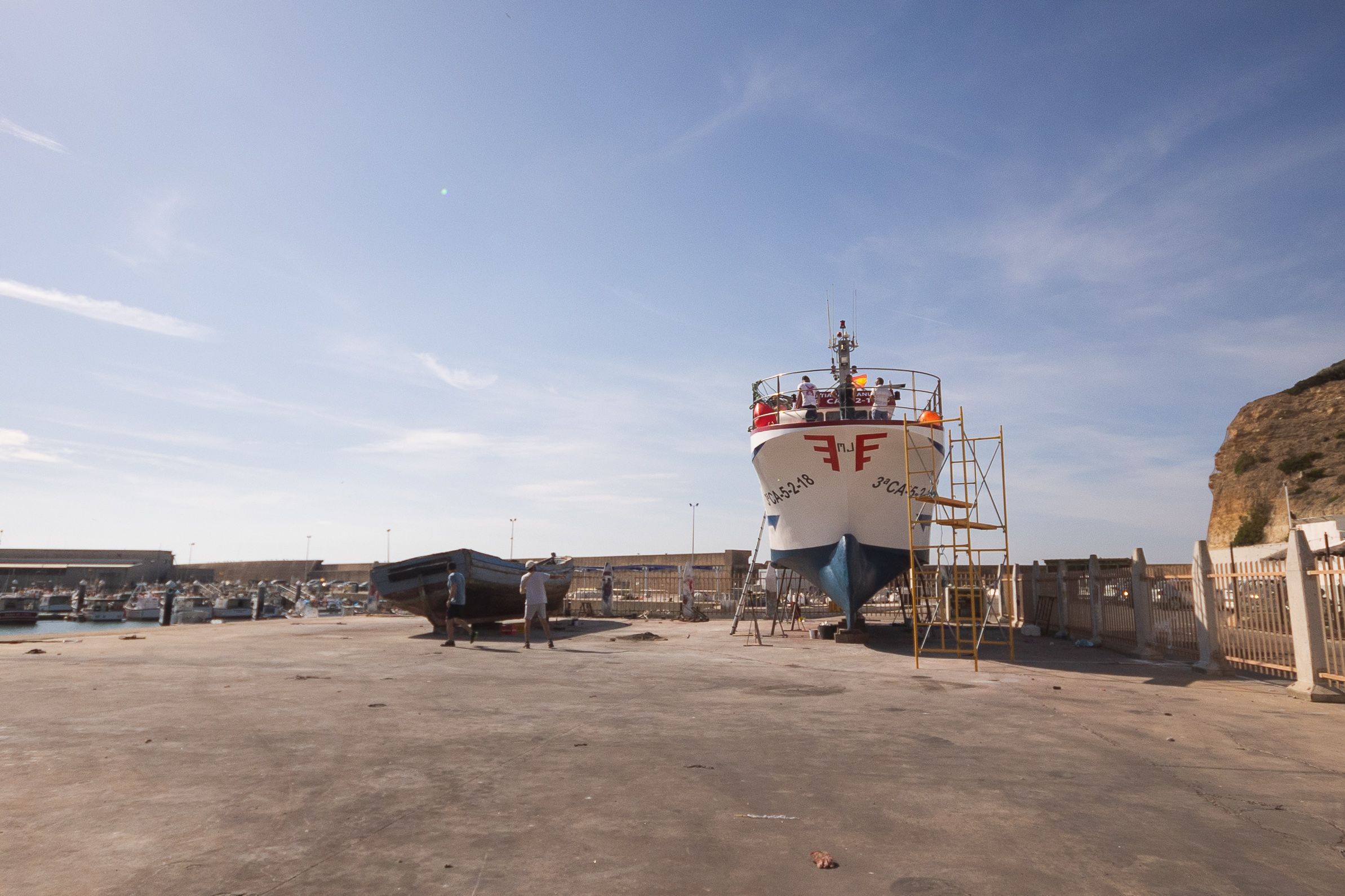Trabajos de mantenimiento en un pesquero en el puerto de Conil.