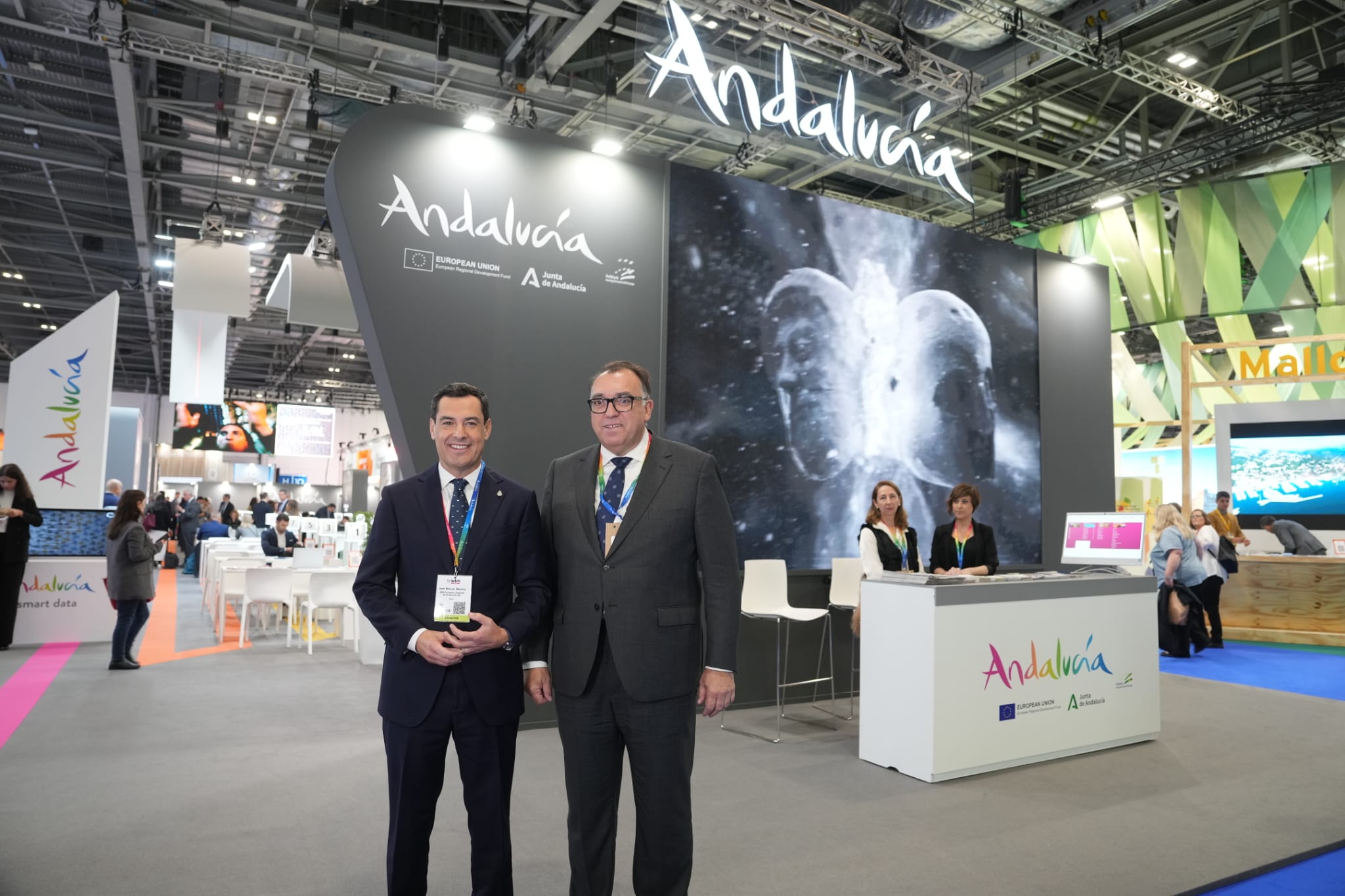 Juanma Moreno y Arturo Bernal, con una escena del 'Andalusian crush' a sus espaldas, en la WTM de Londres de 2023. Juanma Moreno y Arturo Bernal, con una escena del 'Andalusian crush' a sus espaldas, en la WTM de Londres de 2023.