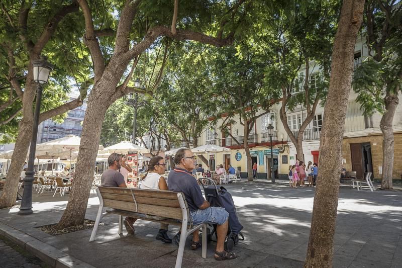 Vecinos sentados en un banco situado junto al perfil de la plaza del Mentidero.