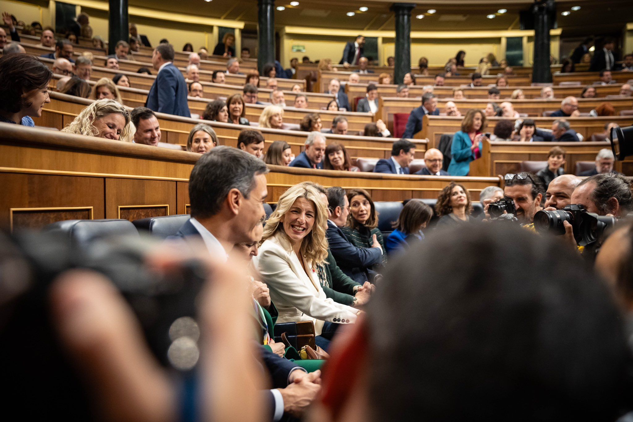 Pedro Sánchez sonríe a Yolanda Díaz durante su investidura.