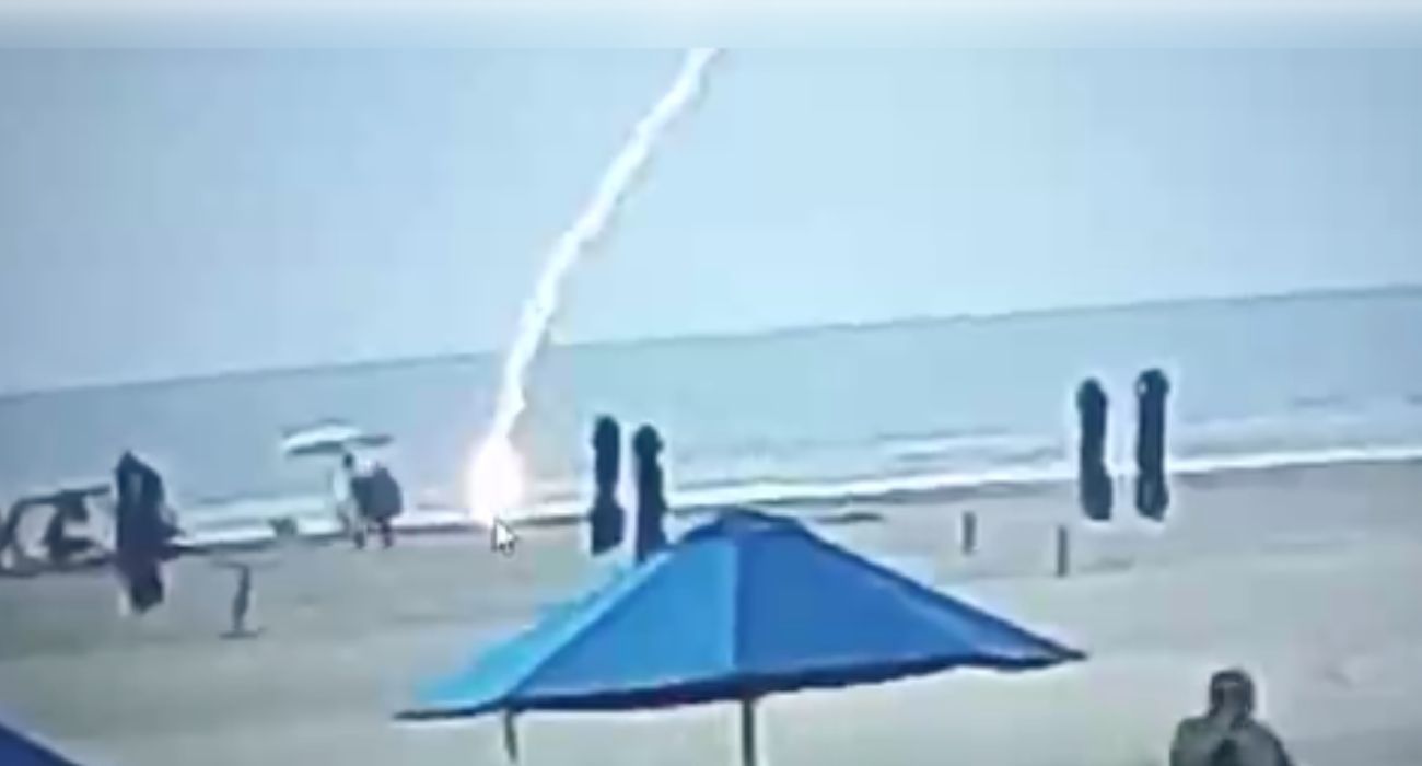 Momento en el que un rayo alcanza a una mujer en una playa. Momento en el que un rayo alcanza a una mujer en una playa.
