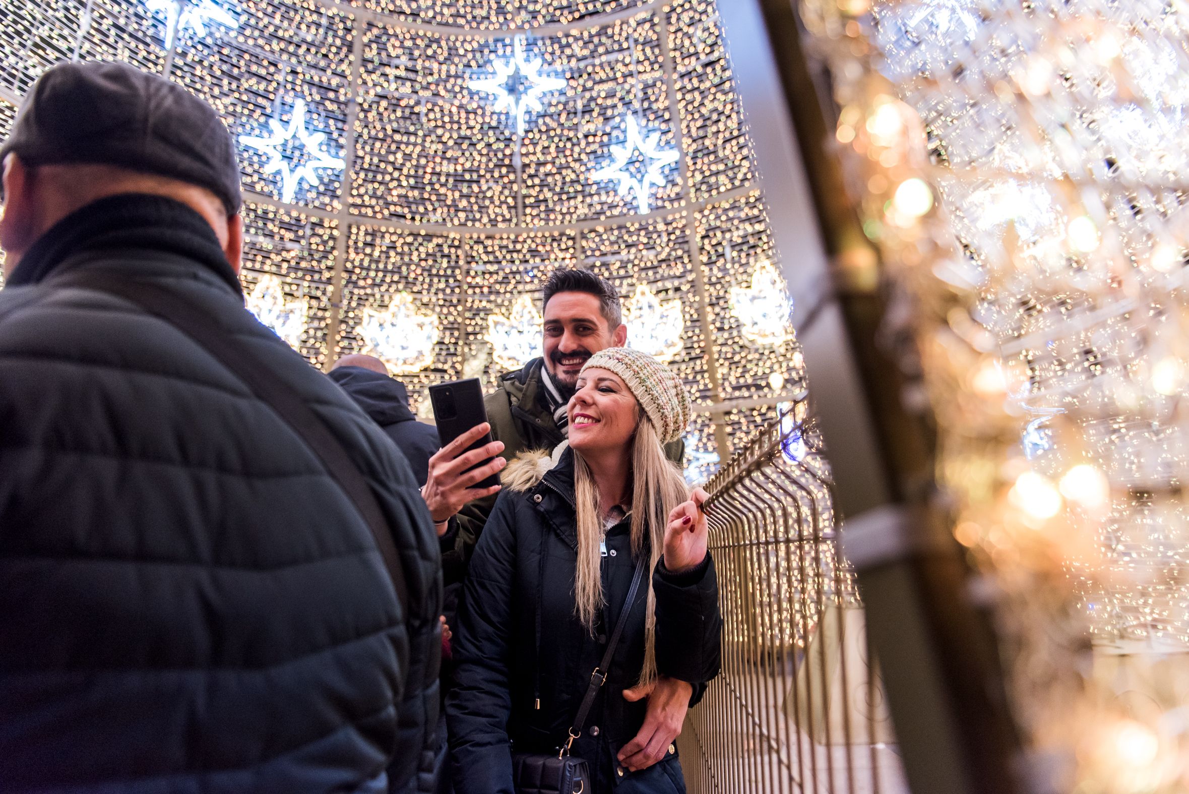 Una pareja se hace un 'selfie' con un árbol navideño.