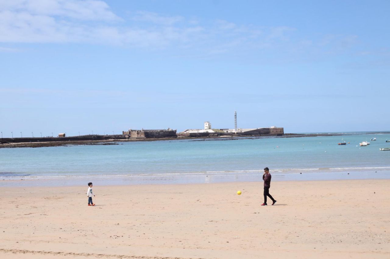 Un padre y un hijo juegan en la playa.