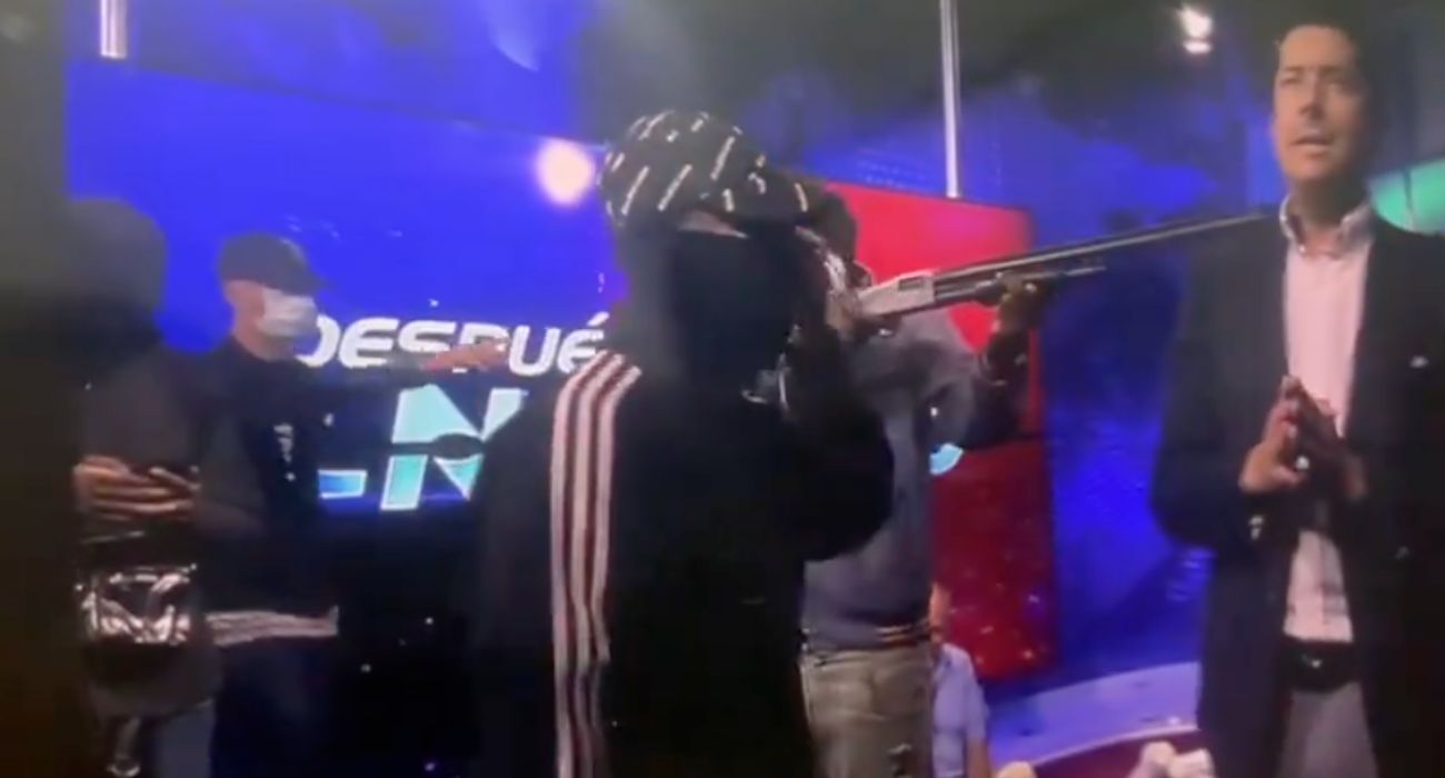 Uno de los encapuchados, encañonando al presentador del programa de televisión. Uno de los encapuchados, encañonando al presentador del programa de televisión.