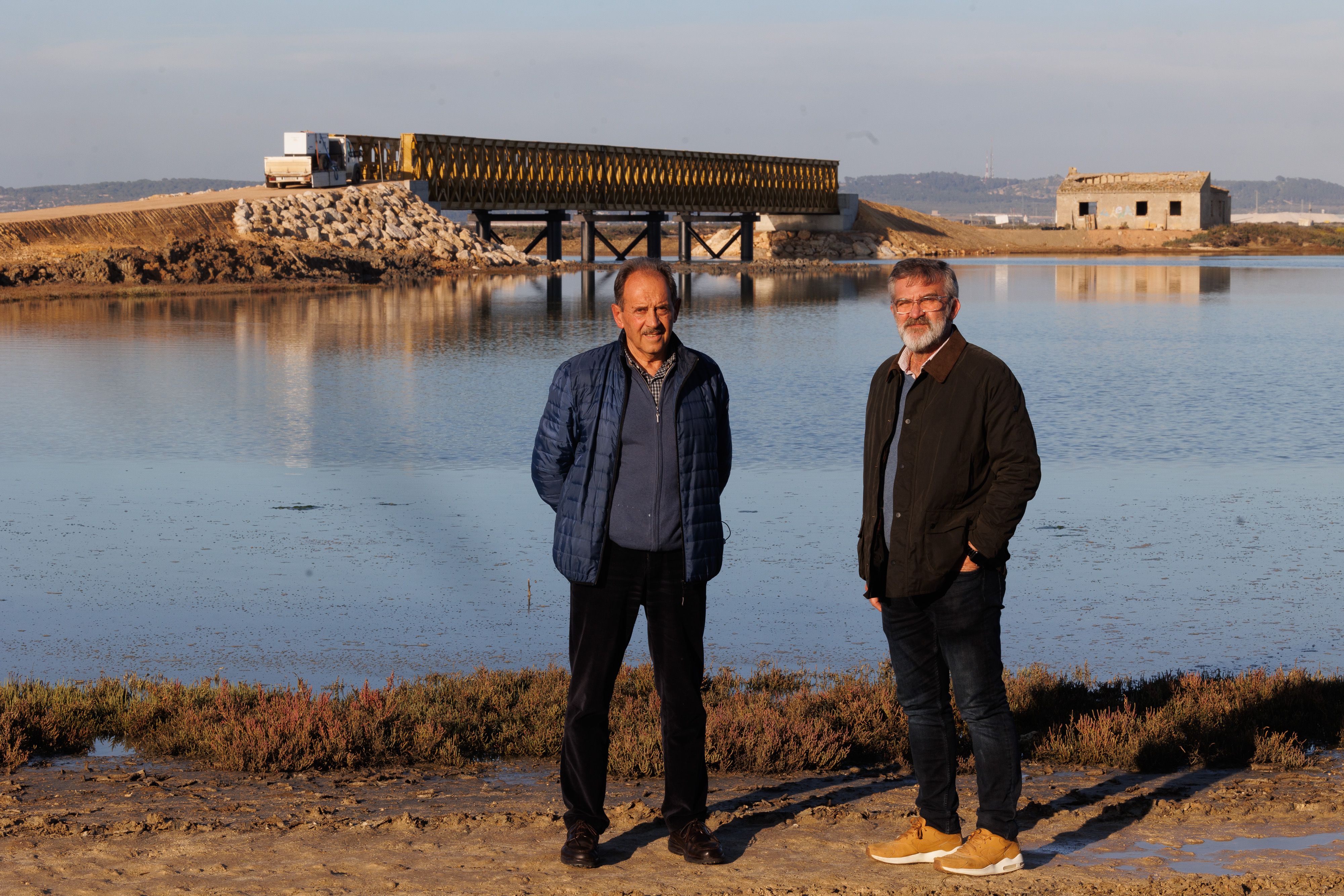 Joaquín Paloma, ecologista, y Miguel Ángel Caballero, técnico de Patrimonio, delante del puente de San Alejandro en el parque natural Bahía de Cádiz.