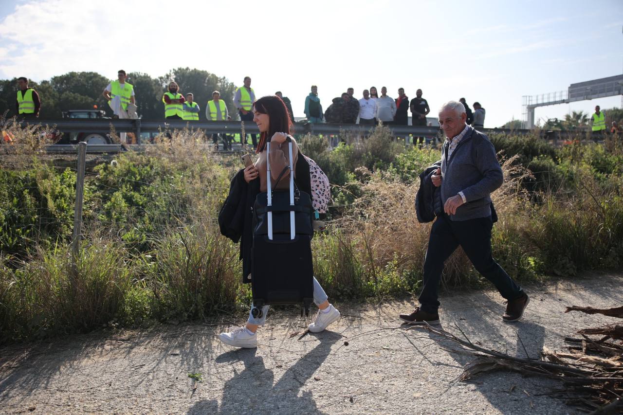 Una mujer porta una maleta en la vía de servicio junto al corte del aeropuerto de Jerez.