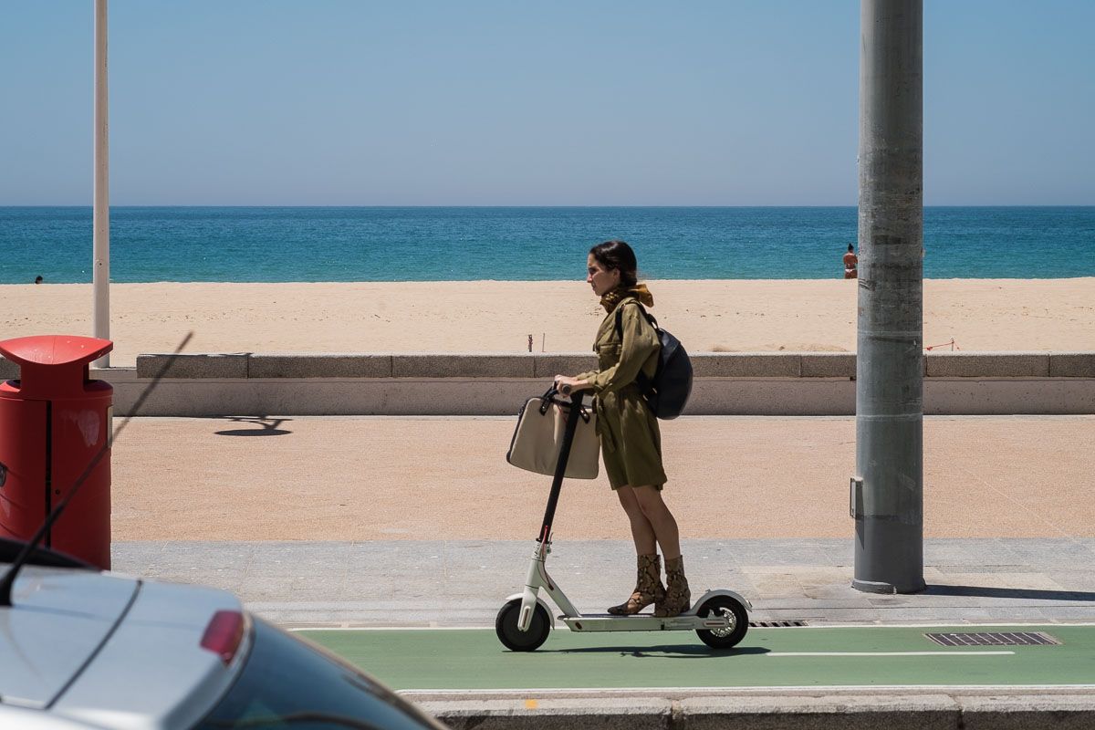 Una mujer en patinete eléctrico, paseando por Cádiz.