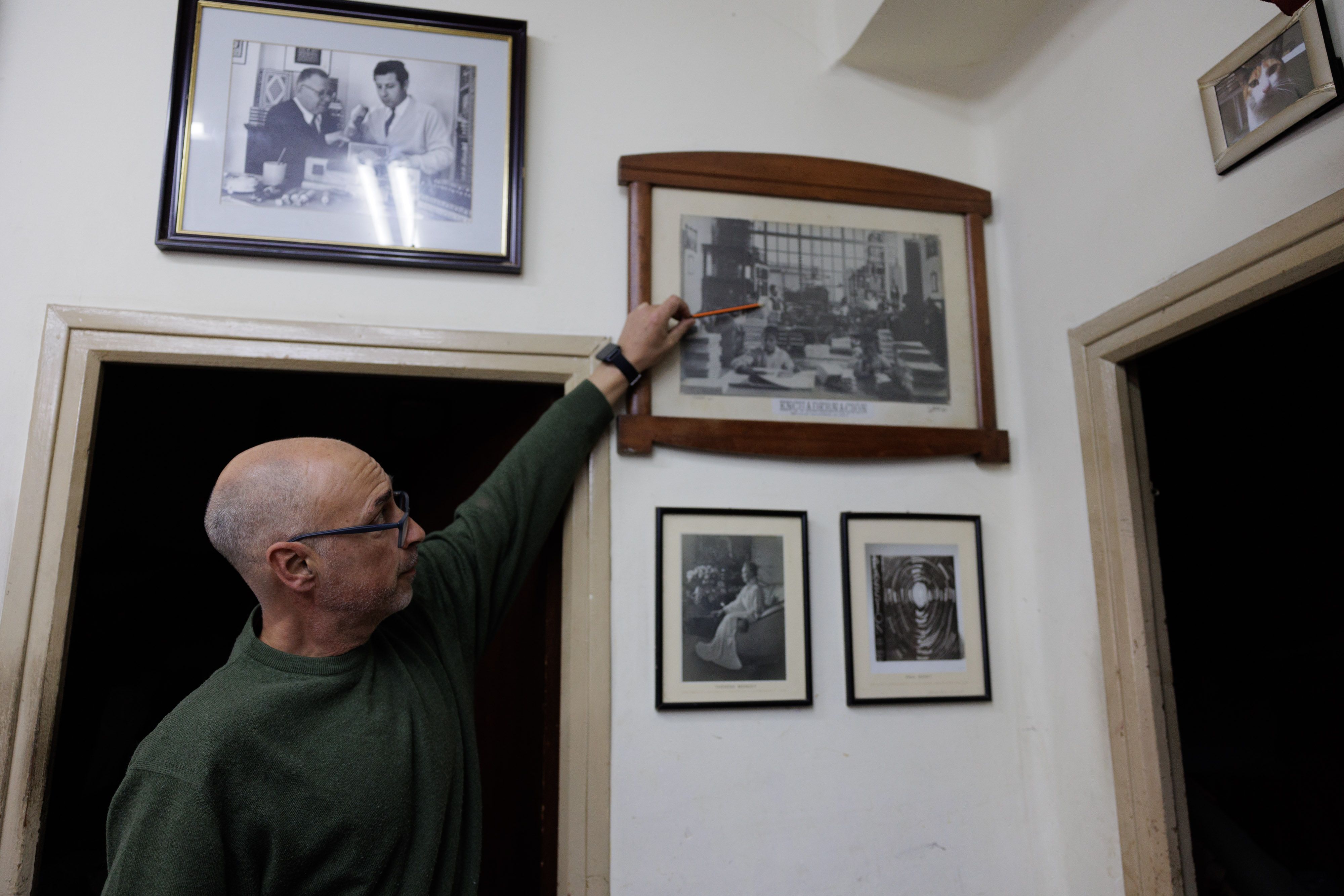 Antonio Galván señala la imagen del fundador del taller.