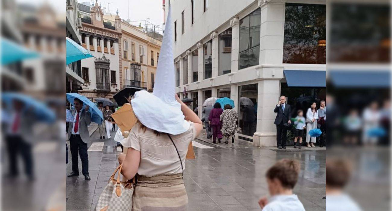Una madre, con el capirote de nazareno de su hijo en la cabeza. Una madre, con el capirote de nazareno de su hijo en la cabeza.