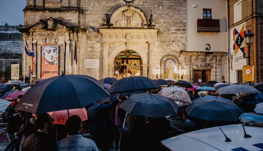 La esquina de la Victoria abarrotada de gente y al fondo, las puertas abiertas de la iglesia con los pasos encendidos. 