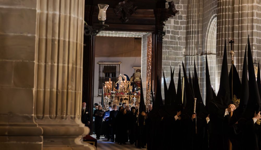 Nazarenos de La Mortaja en la Catedral con el paso a punto de acceder al templo.