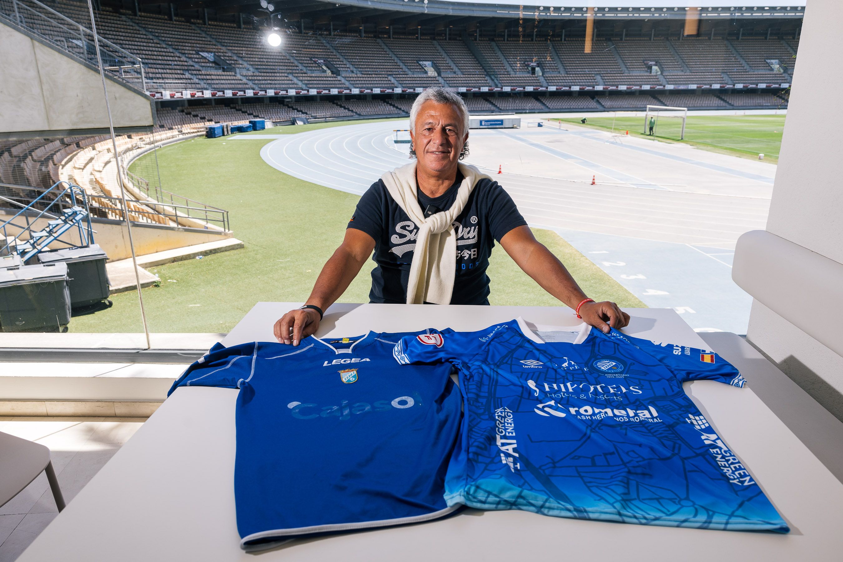 Néstor 'Pipo' Gorosito posa, tras la entrevista con lavozdelsur.es, con las dos camisetas de los dos Xerez, con el fondo del estadio municipal Chapín, este viernes en Jerez.