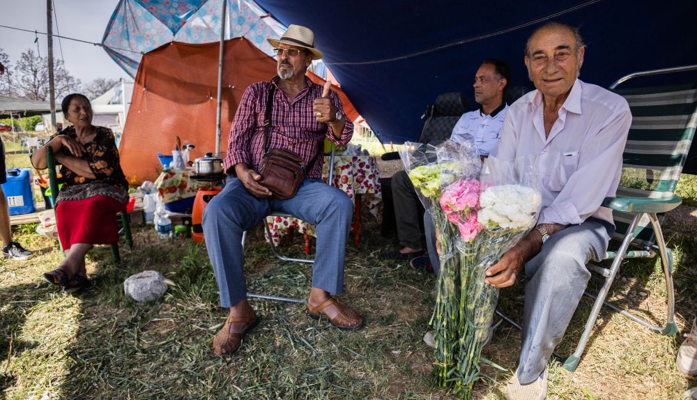 Las familias muestran los claveles que han comprado en Chipiona.