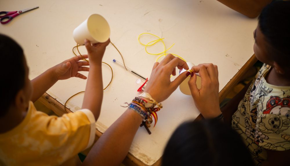 Los niños y niñas colocan la cuerda a los vasos.