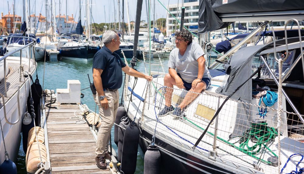 El jefe de operaciones conversa con Vicente, regatista.