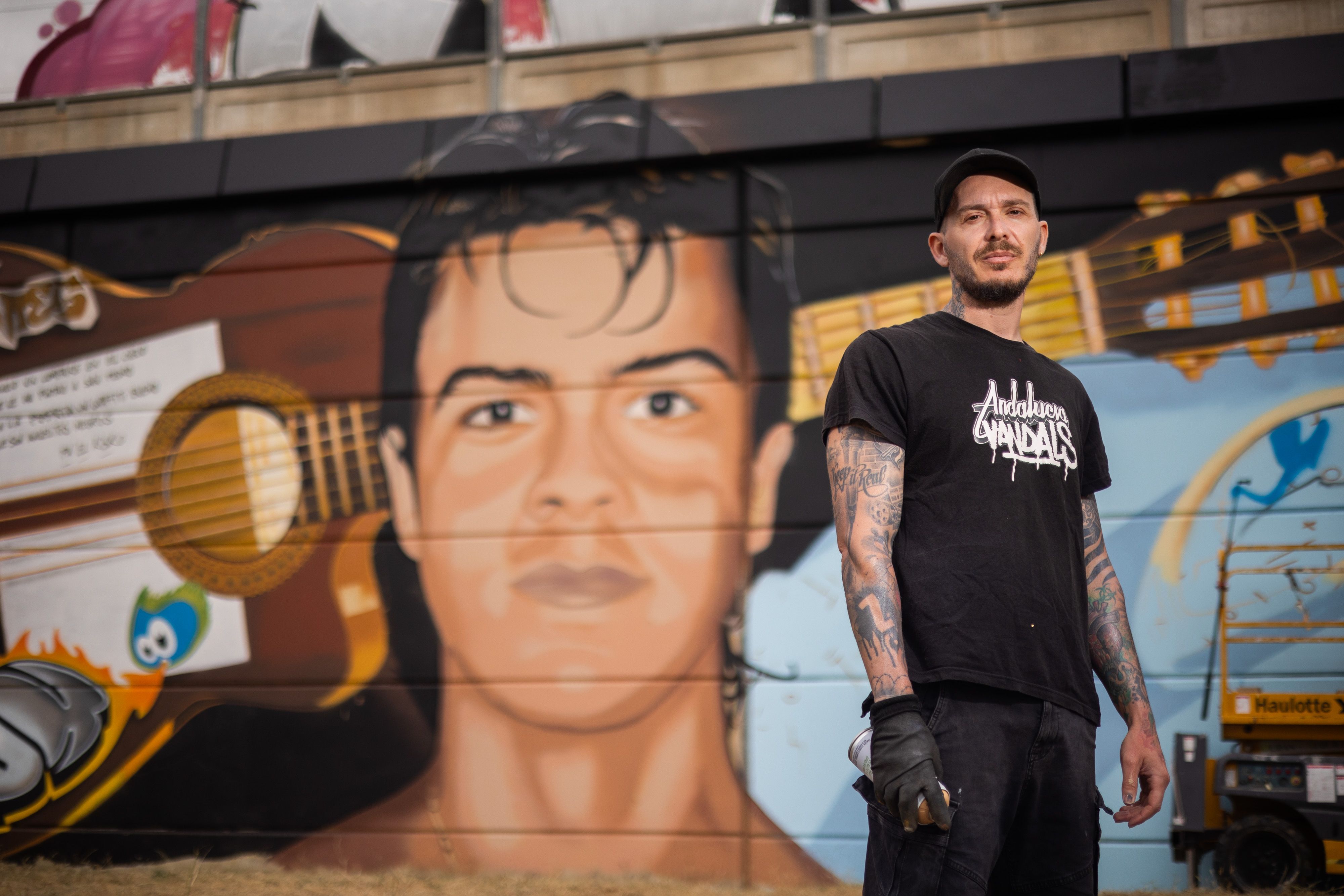 Fran Castro, Cosa.V, con el grafiti de Migue Benítez al fondo.