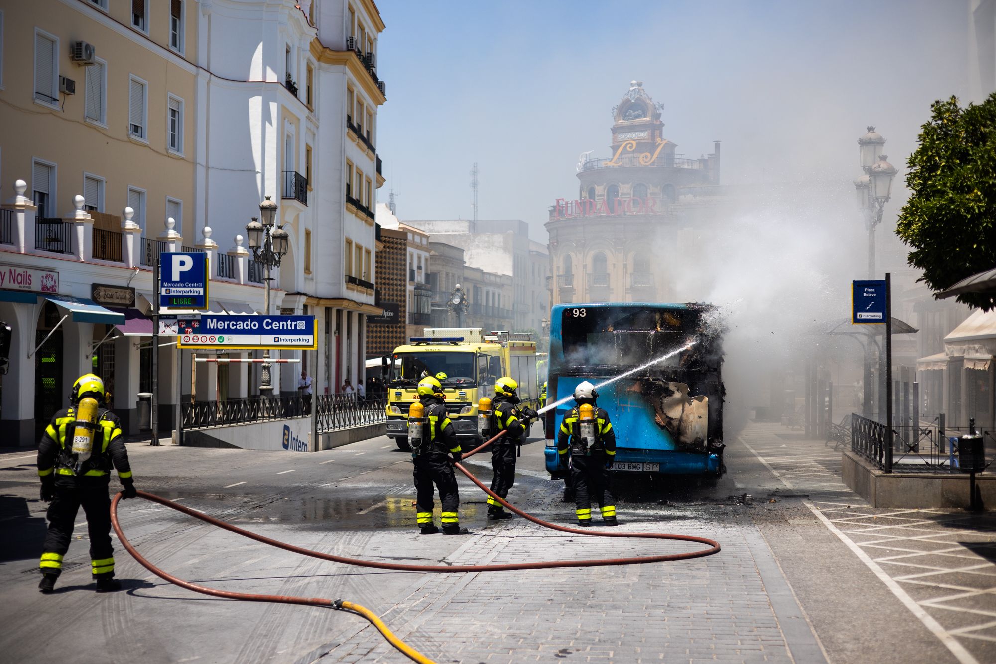 La actuación de los bomberos en el incendio del autobús en pleno centro de Jerez, en imágenes.