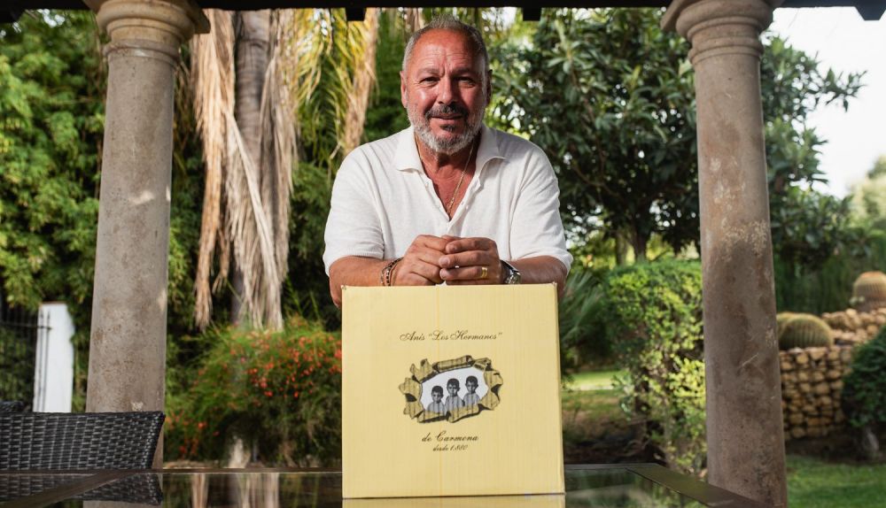 José Antonio Rodríguez posa junto a una caja de Anís Los Hermanos, destilado en su finca de manera artesanal desde 1880.