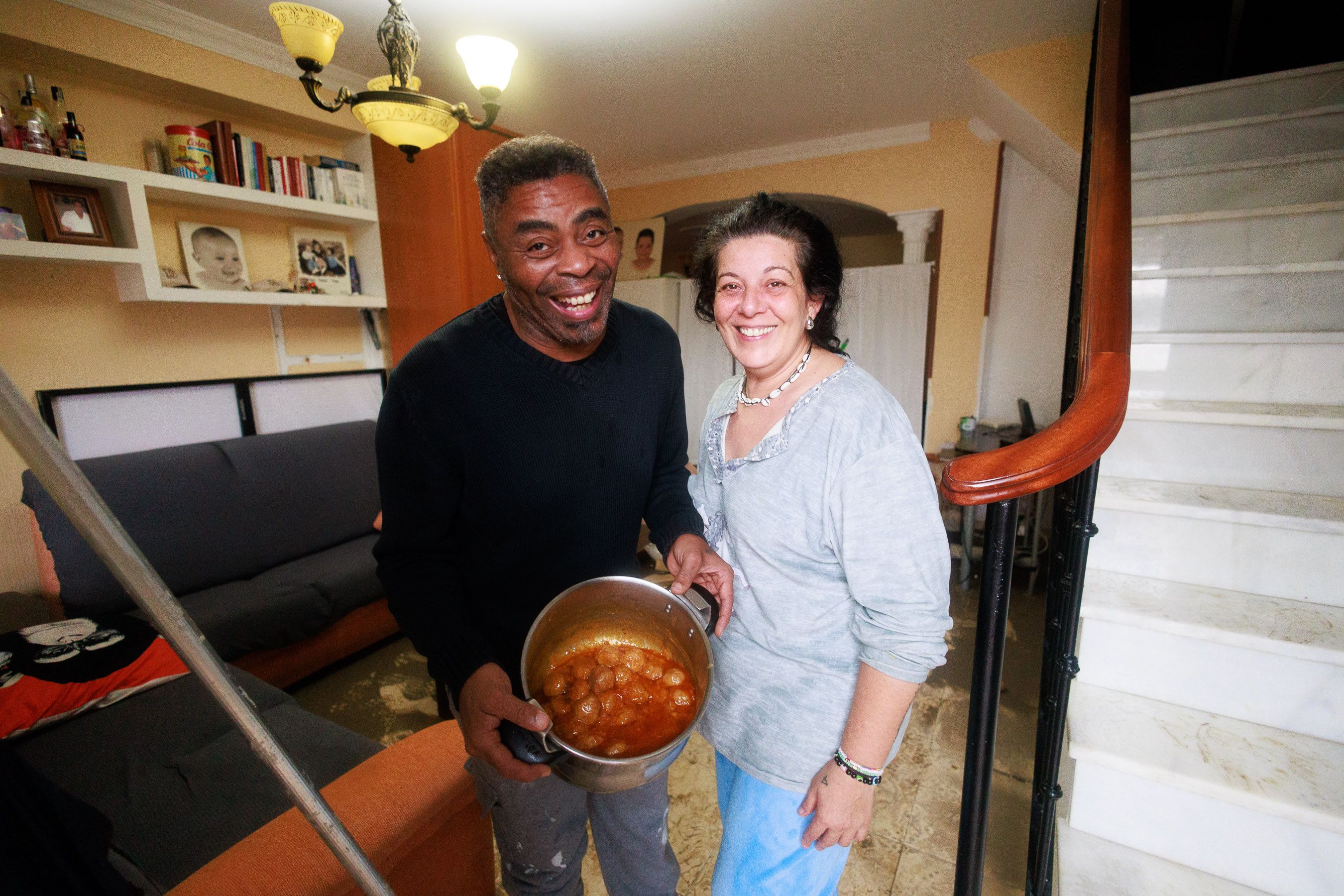 Valentín Ndongo y Lourdes Barriga, en el salón de su casa, con la olla de albóndigas.