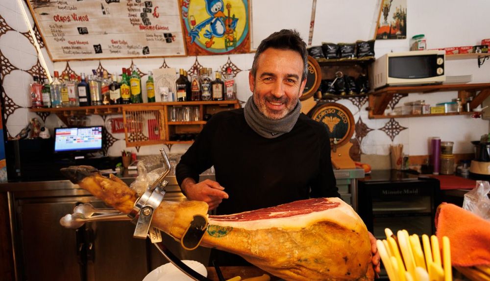 Piñero tras la barra y ante un jamón.