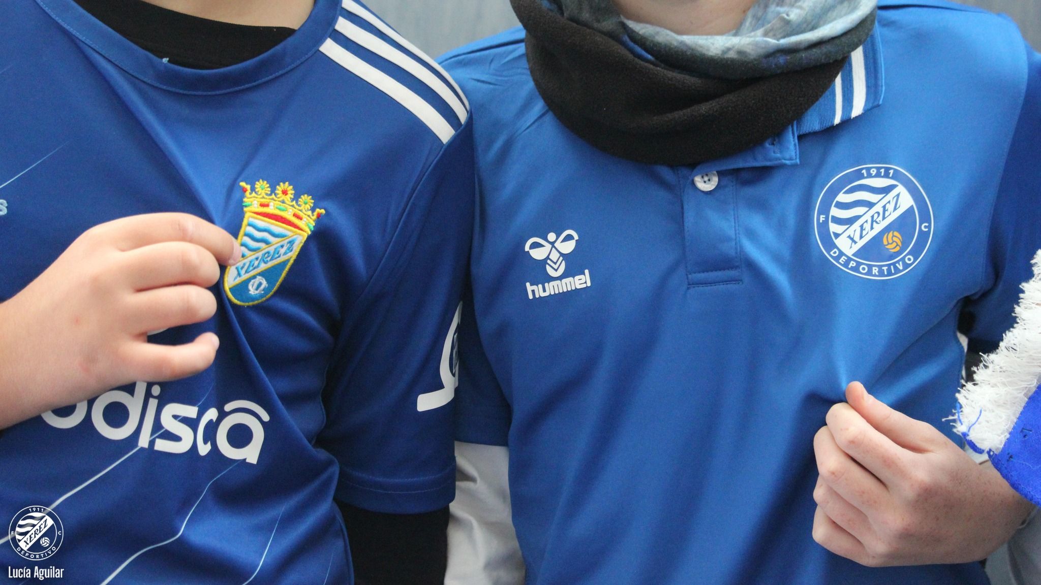 Dos personas con las camisetas del Xerez CD y el Xerez DFC.