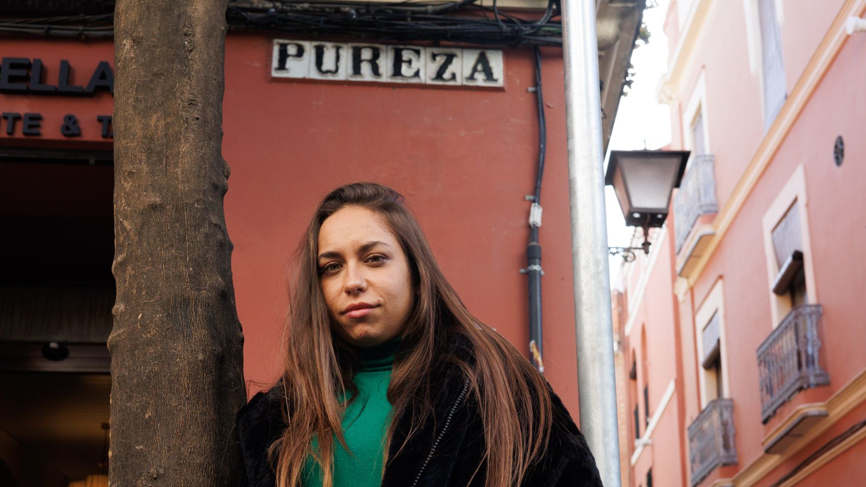 María Terremoto posa, tras la entrevista con lavozdelsur.es, bajo el rótulo de la calle Pureza, una de las vías principales de Triana, recordando aquella imagen donde Colita inmortalizó a Antonio Mairena en el mismo punto de Sevilla.