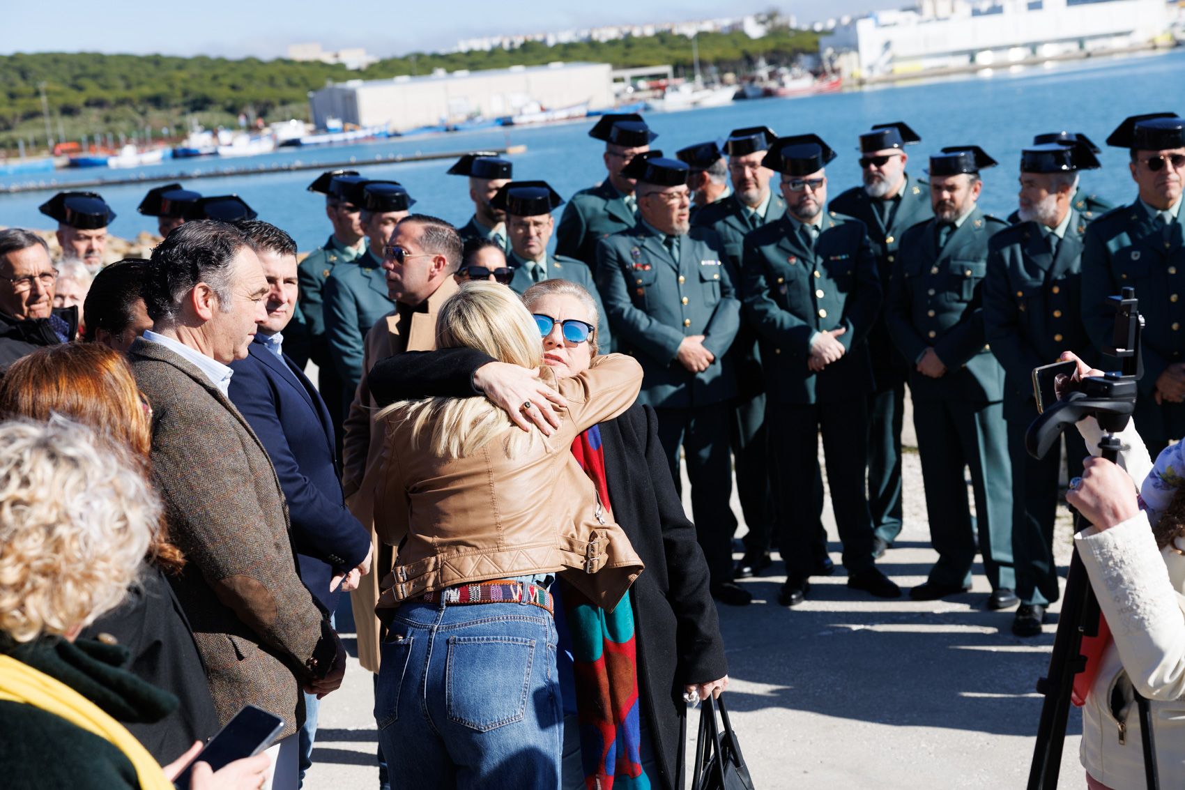 La madre de uno de los fallecidos recibe un abrazo en el puerto de Barbate este domingo.