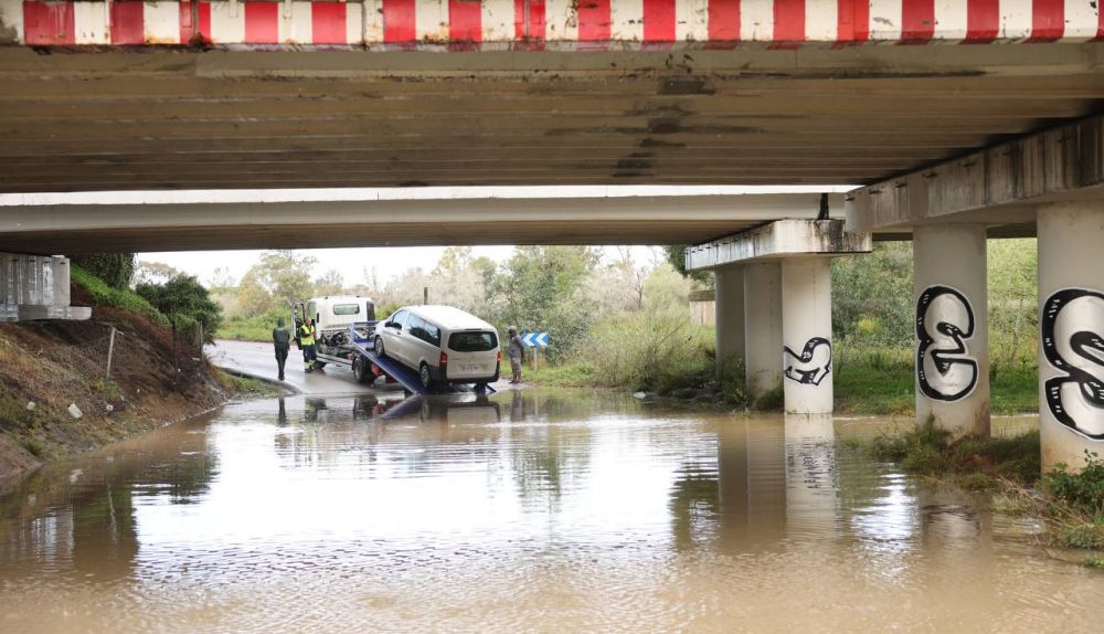 Un coche bajo el puente de la autopista de La Cartuja, atrapado por la crecida del Guadalete, este lunes.