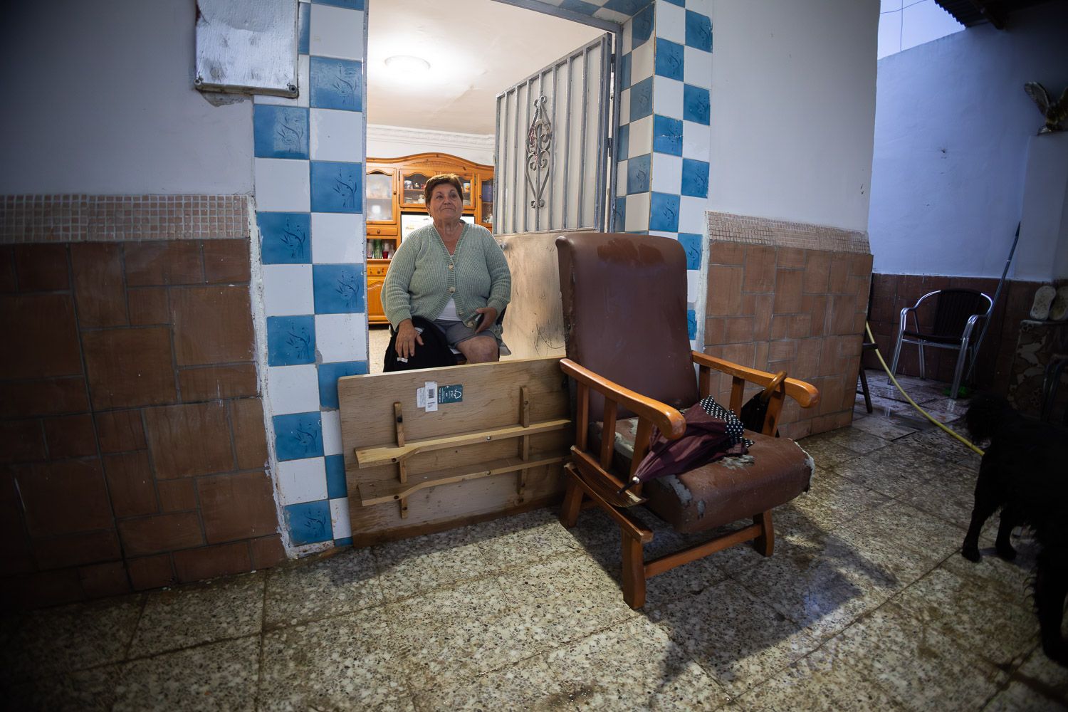 Una vecina de la carretera de El Calvario, con una tabla para evitar la entrada de agua en su casa. 