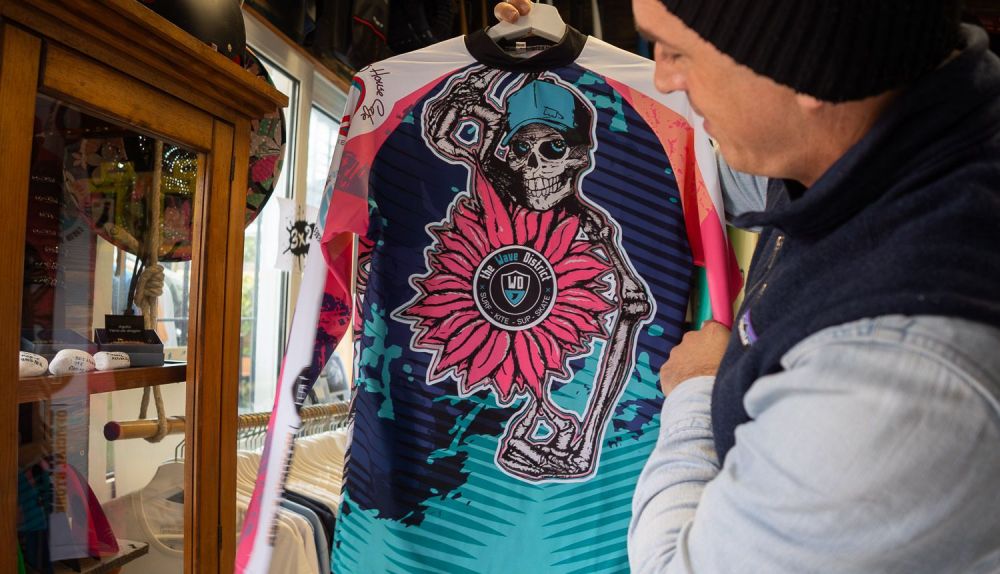El surfista enseña una prenda.