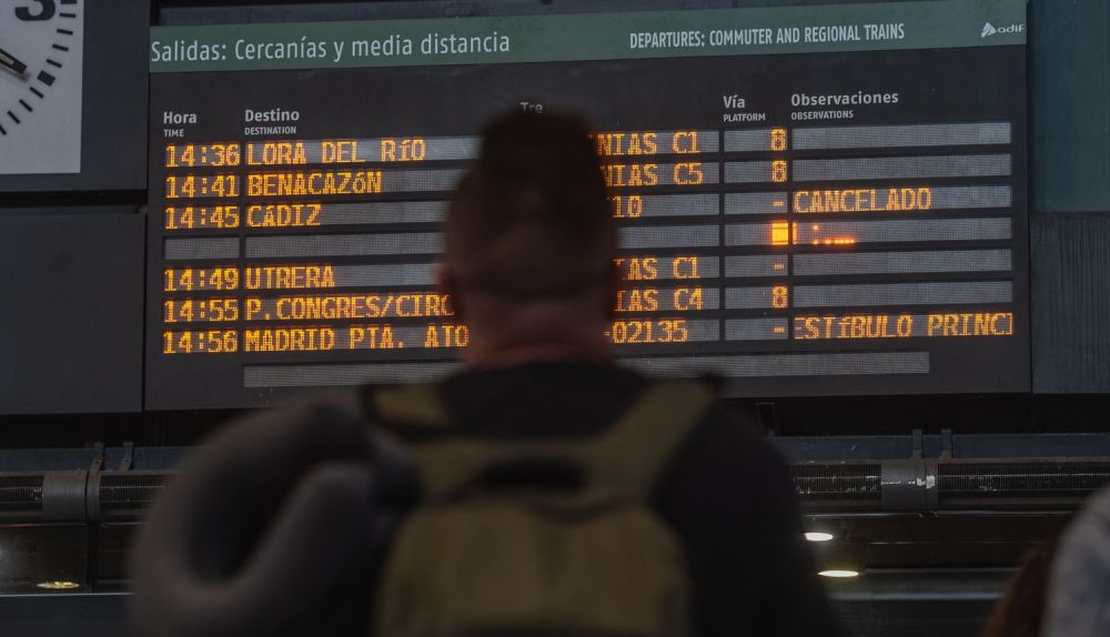 Una pasajera, frente a los carteles que avisan del tren cancelado destino Cádiz, en Santa Justa, este mediodía del martes.
