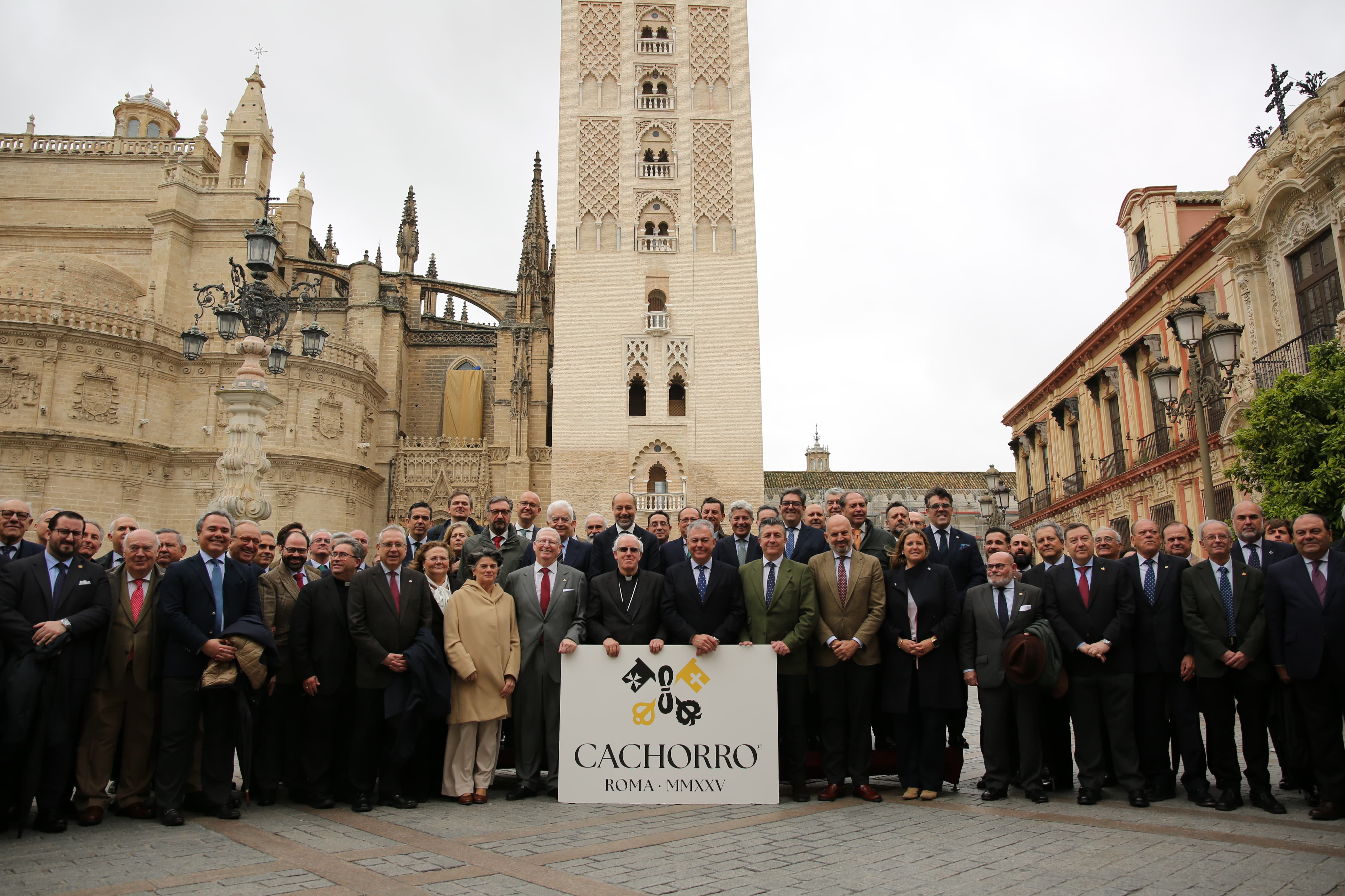 Autoridades y hermanos mayores en una foto de familia al pie de la Giralda. 