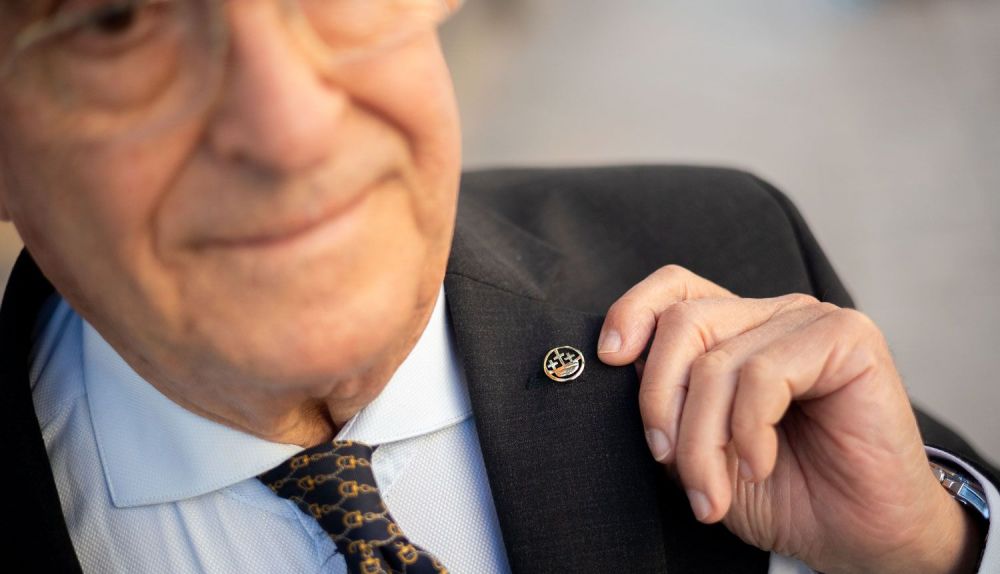 Enseñando la insignia de la Hermandad del Cristo. 