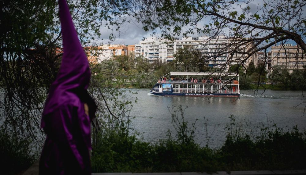 Un nazareno de La O por el río.
