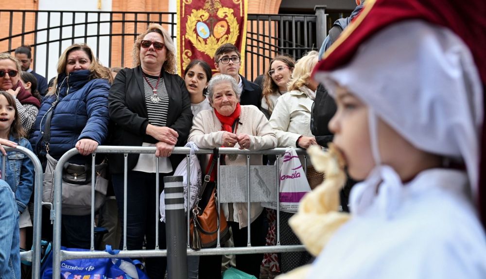 Una mujer mira atentamente a un pequeño nazareno en el Cerro.