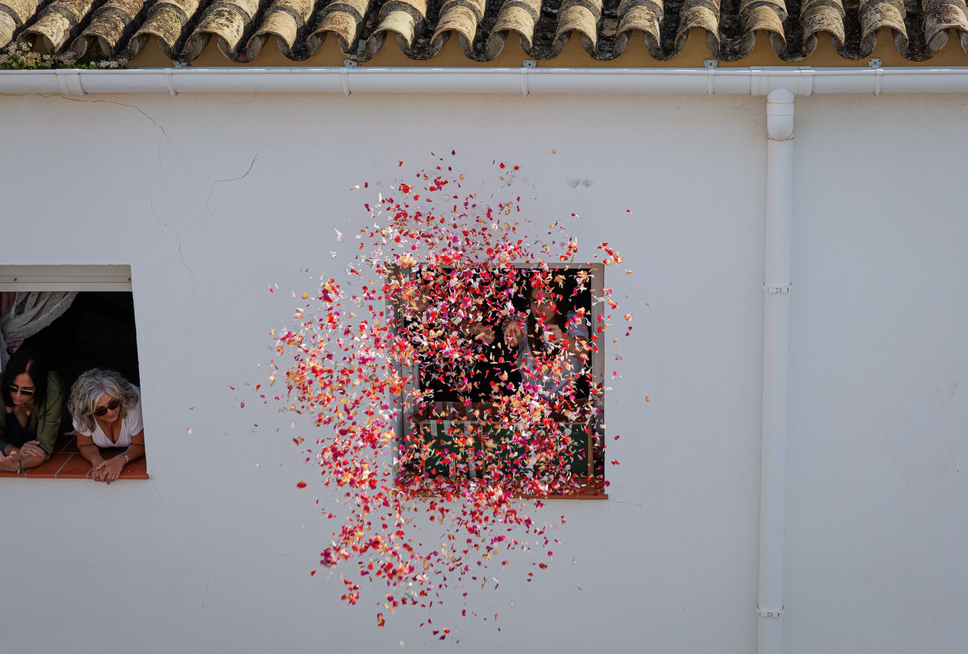 Un manto de pétalos desde una ventana de La Plazuela para Nuestro Padre Jesús de la Sentencia.