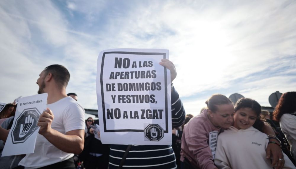 Una trabajadora de comercios enseña una pancarta durante la protesta contra la apertura tras anularse la ZGAT.
